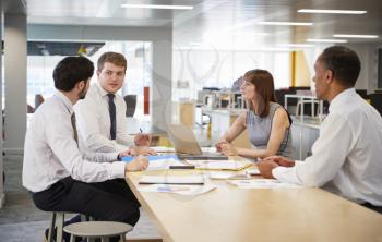 Business colleagues brainstorming in an open plan office