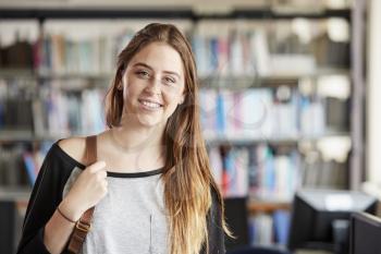Portrait Of Female Student Standing In College Library