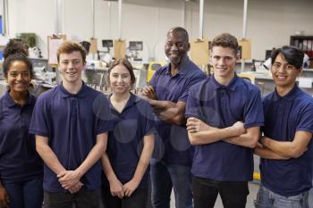 Portrait Of Engineer And Apprentices In Factory