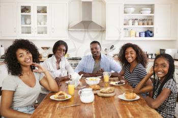 Portrait Of Family With Teenage Children Eating Breakfast