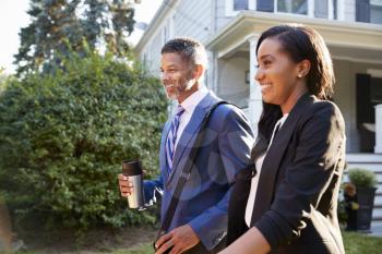Business Couple Leaving Suburban House For Commute To Work