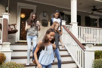 Four teen girlfriends leaving house for school