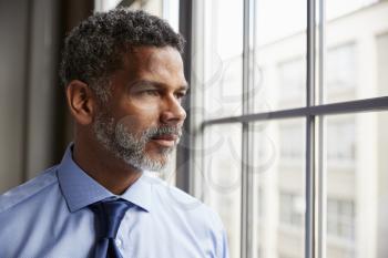 Middle aged black businessman looking out of window