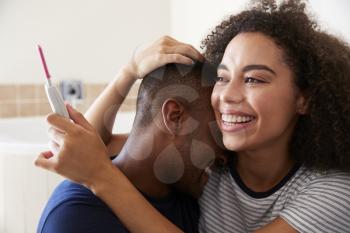 Couple Celebrating Positive Home Pregnancy Test Result