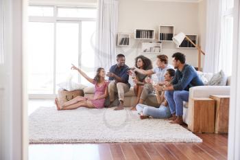 Group Of Friends Relaxing At Home Watching TV Together