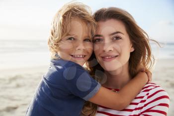 Portrait Of Mother Hugging Son On Summer Beach Vacation