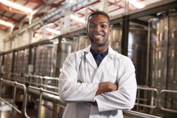 Young black male wine factory technician smiling to camera