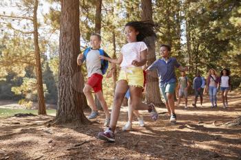 Children Running Ahead Of Parents On Family Hiking Adventure