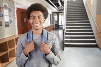 Portrait Of Male High School Student Standing By Stairs In College Building