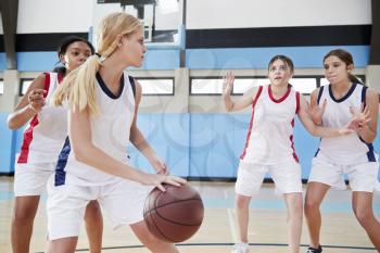 Female High School Basketball Team Dribbling Ball On Court