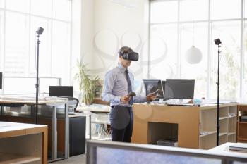 Businessman using VR technology in an office, side view