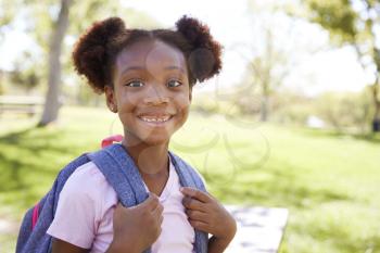 Young black schoolgirl smiling to camera, portrait