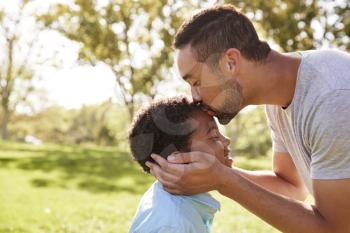 Close Up Of Father Kissing Son In Park