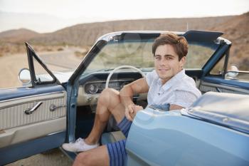 Portrait Of Man Enjoying Road Trip In Open Top Classic Car