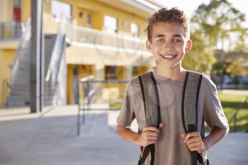 Portrait of smiling elementary school boy with his backpack