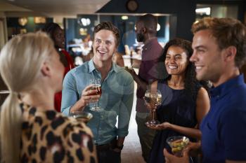 Group Of Young Friends Relaxing In Bar Together On Night Out