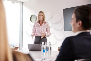 Mature Businesswoman Addressing Group Meeting Around Table At Graduate Recruitment Assessment Day