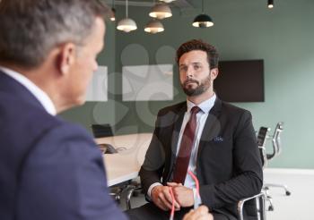 Businessman Interviewing Male Candidate At Graduate Recruitment Assessment Day In Office