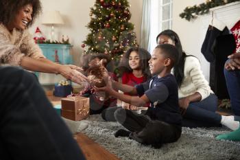 Son Giving Mother Gift As Multi Generation Family Celebrate Christmas At Home Together