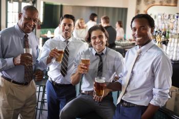 Portrait Of Businessmen Meeting For After Works Drinks In Bar
