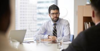Businessman With Digital Tablet Sitting At Table Meeting With Colleagues In Modern Office