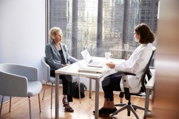 Worried Senior Woman Having Consultation With Female Doctor In Hospital Office
