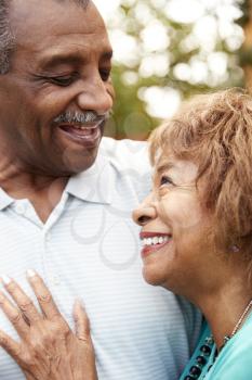 Senior black husband and wife embracing, close up, vertical