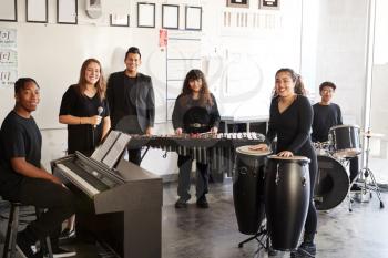 Portrait Of Students At Performing Arts School Playing In Band At Rehearsal With Teacher