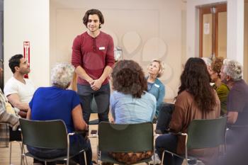 Man Standing To Address Self Help Therapy Group Meeting In Community Center
