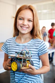 Portrait Of Female Student Building Robot Vehicle In After School Computer Coding Class
