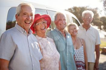 Portrait Of Senior Friends Standing Together Beside Van On Vacation