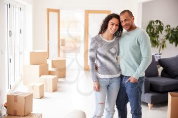 Portrait Of Loving Couple Surrounded By Boxes In New Home On Moving Day