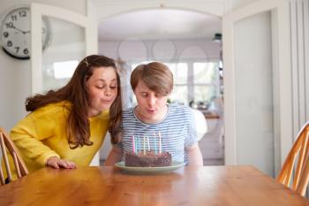 Young Downs Syndrome Couple Celebrating Birthday At Home With Cake