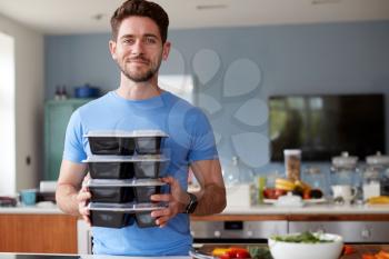 Portrait Of Man Preparing Batch Of Healthy Meals At Home In Kitchen