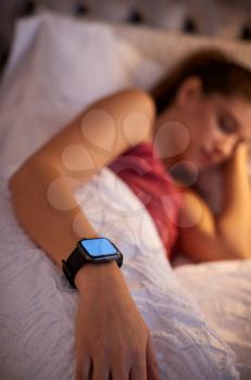 Woman Sleeping In Bed With Focus On Smart Watch She Is Wearing