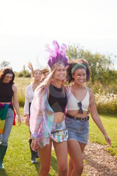 Female Friends Walking Back To Tent After Outdoor Music Festival