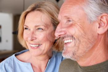 Close Up Of Smiling Senior Couple Standing At Home In Kitchen Together