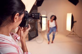 Model Posing For Female Photographer In Studio Portrait Session