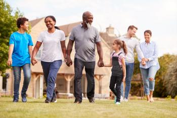 Smiling Multi-Generation Mixed Race Family Walking In Garden At Home