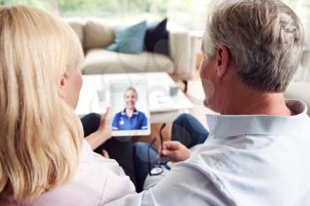 Mature Couple Having Online Consultation With Female Nurse At Home On Digital Tablet