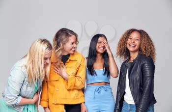 Group Studio Portrait Of Multi-Cultural Female Friends Smiling Into Camera Together
