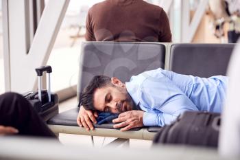 Businessman Sleeping On Seats In Airport Departure Lounge Because Of Delay