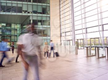 Motion Blur Shot Of Businesspeople In Lobby Of Busy Modern Office