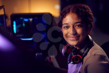 Portrait Of Teenage Girl With Headset Gaming At Home Using Dual Computer Screens