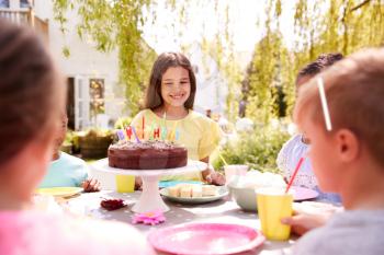 Girl Celebrating Birthday With Friends Having Party In Garden At Home