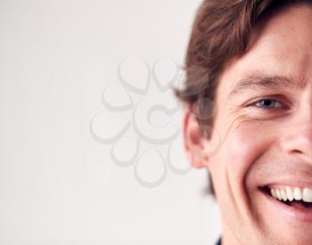 Close Up On Face Of Laughing Man Standing In Studio