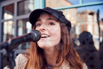 Female Musician Busking Singing Outdoors In Street