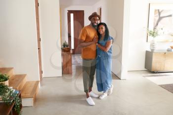 Portrait Of Loving African American Couple Hugging In Hall At Home