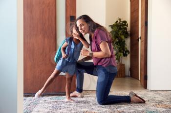Daughter Whispering To Mother As She Leaves Home For School