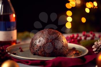 Brandy Soaked Christmas Pudding On Table Set For Festive Christmas Meal
